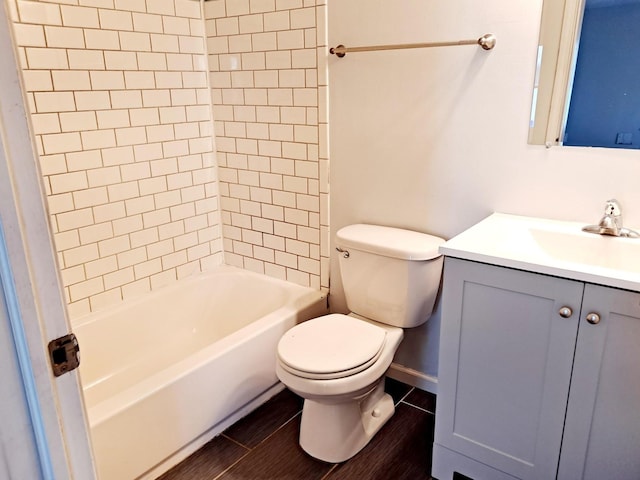 full bathroom featuring vanity, tiled shower / bath, and toilet