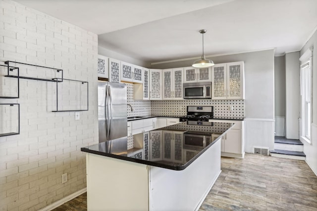 kitchen with a kitchen bar, a center island, hanging light fixtures, appliances with stainless steel finishes, and white cabinets