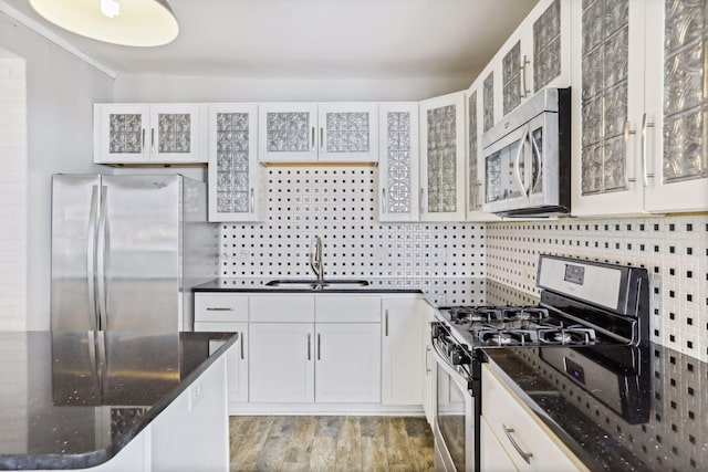 kitchen with tasteful backsplash, white cabinetry, appliances with stainless steel finishes, and sink