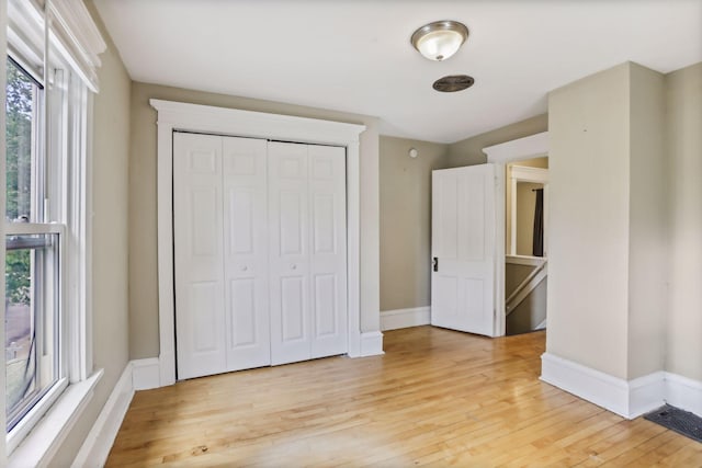 unfurnished bedroom featuring a closet and light wood-type flooring