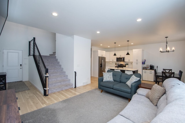 living room featuring an inviting chandelier and light hardwood / wood-style floors