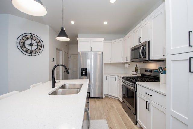 kitchen featuring sink, tasteful backsplash, decorative light fixtures, stainless steel appliances, and white cabinets