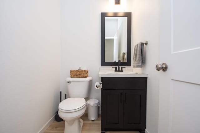 bathroom with vanity, hardwood / wood-style floors, and toilet