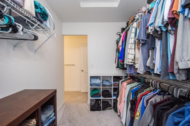 walk in closet featuring light carpet