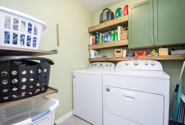 washroom featuring washer and clothes dryer and cabinets