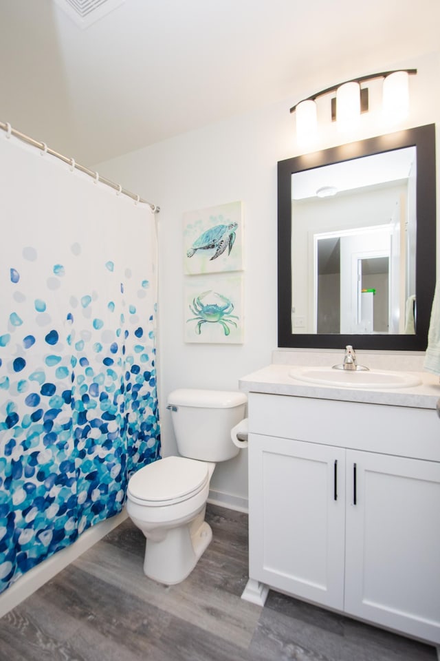 bathroom featuring wood-type flooring, vanity, and toilet