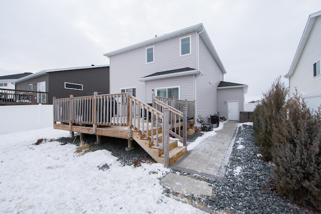 snow covered property featuring a wooden deck