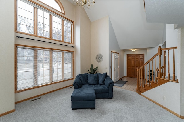 interior space with an inviting chandelier, high vaulted ceiling, and light carpet