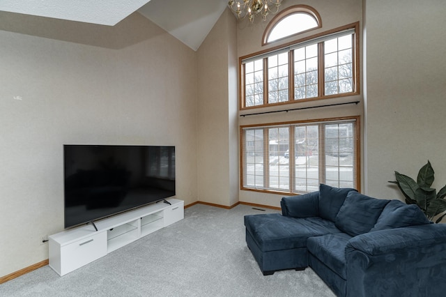 living room featuring light colored carpet, high vaulted ceiling, and a notable chandelier