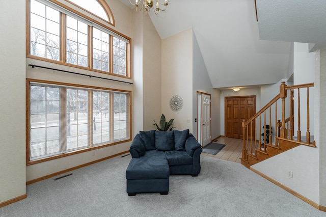 interior space with a notable chandelier, light colored carpet, and high vaulted ceiling