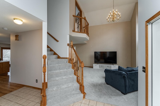 staircase featuring an inviting chandelier, vaulted ceiling, and carpet floors