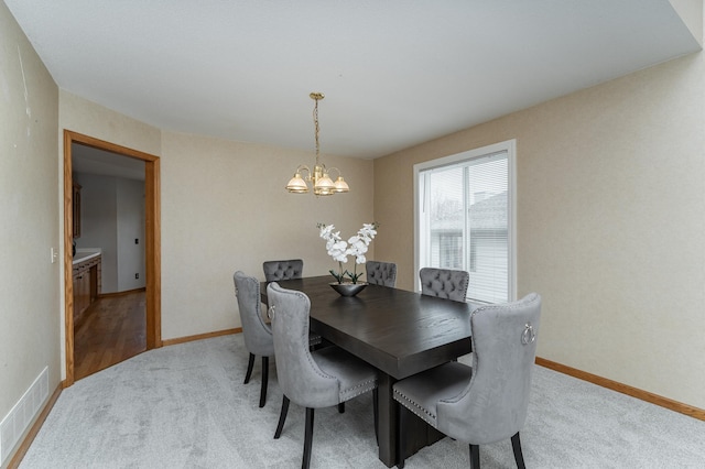 carpeted dining space with a chandelier