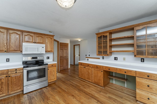 kitchen with built in desk, a textured ceiling, stainless steel range with electric cooktop, and light hardwood / wood-style flooring