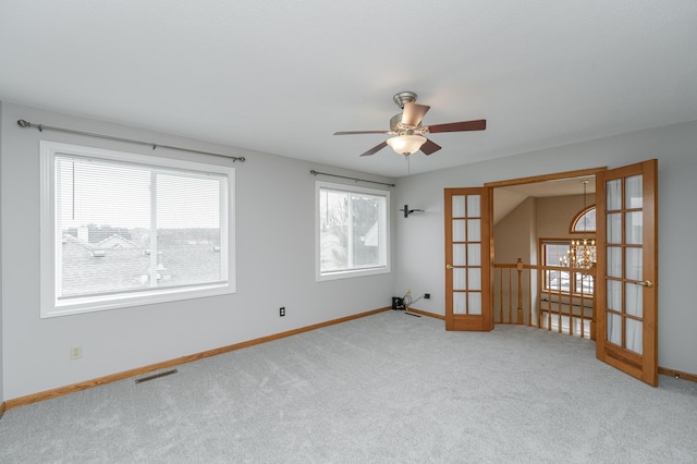 empty room featuring french doors, ceiling fan, plenty of natural light, and carpet flooring