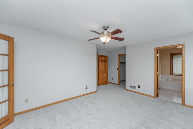 carpeted spare room featuring ceiling fan and a textured ceiling