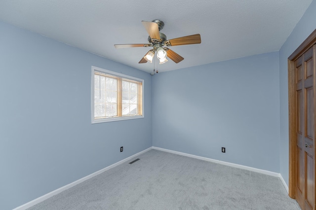 spare room with light colored carpet and ceiling fan