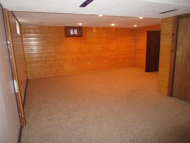 basement with wooden walls and carpet floors