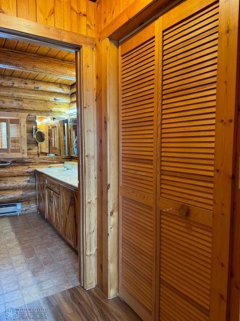 bathroom featuring beamed ceiling, rustic walls, and wood ceiling