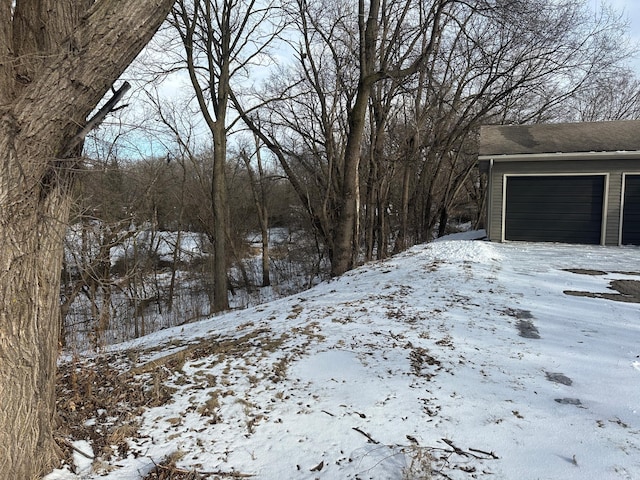 snowy yard featuring a garage