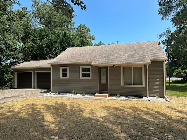 ranch-style home featuring a garage and a front lawn