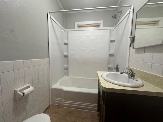 full bathroom featuring shower / washtub combination, tile walls, hardwood / wood-style flooring, vanity, and toilet