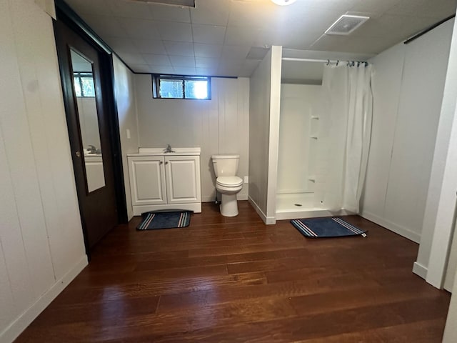 bathroom with hardwood / wood-style flooring, vanity, curtained shower, and toilet