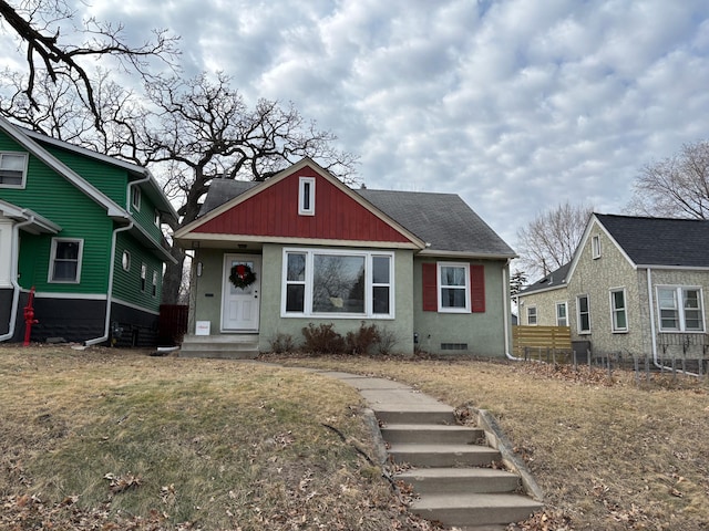 bungalow-style house featuring a front lawn