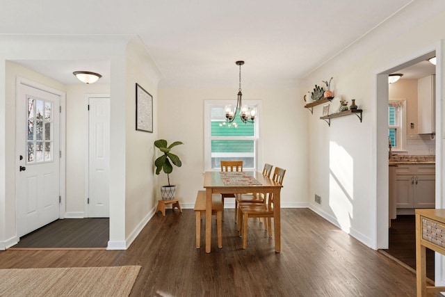 dining space with a chandelier, dark wood-style flooring, plenty of natural light, and baseboards