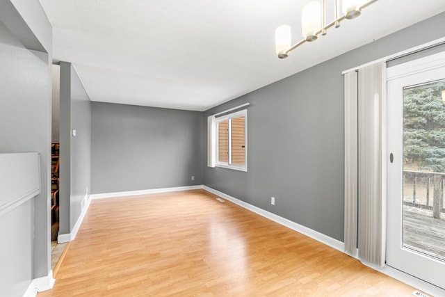 unfurnished living room with wood-type flooring and a notable chandelier