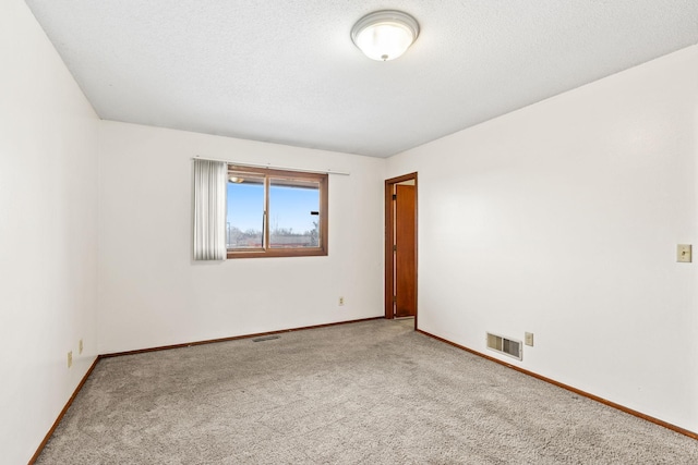 carpeted spare room featuring a textured ceiling