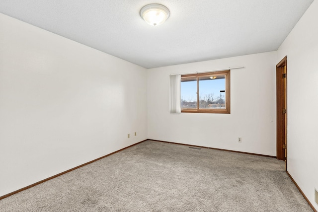 spare room featuring carpet floors and a textured ceiling