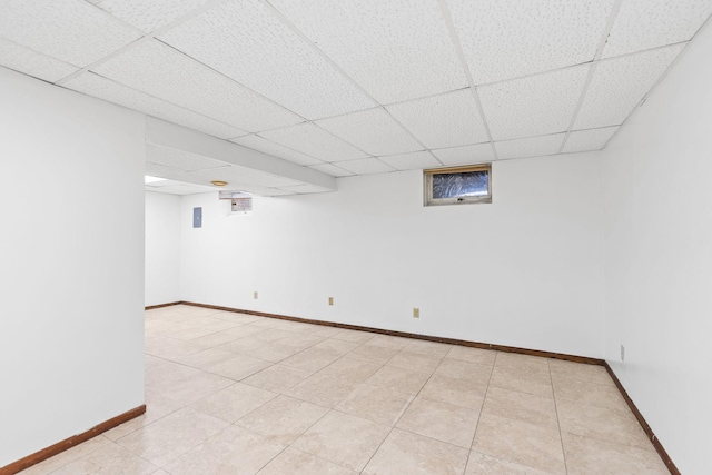 basement with light tile patterned flooring and a paneled ceiling