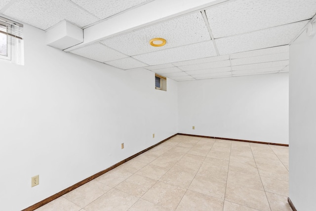 basement featuring light tile patterned floors and a drop ceiling