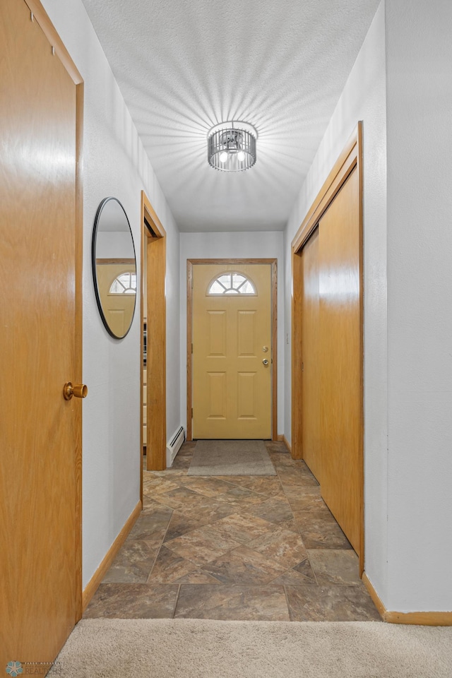 doorway featuring a baseboard radiator and a textured ceiling