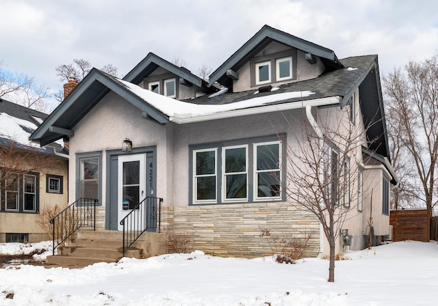 bungalow featuring stone siding and stucco siding