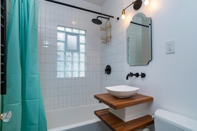 full bathroom featuring a sink, toilet, and shower / bathtub combination with curtain