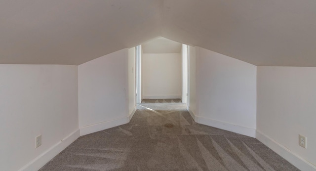 additional living space featuring carpet floors, vaulted ceiling, and baseboards