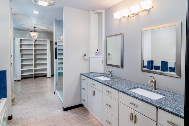 bathroom featuring hardwood / wood-style flooring, vanity, a chandelier, and walk in shower