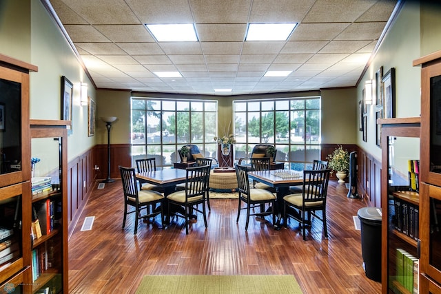 dining area featuring dark wood-type flooring, ornamental molding, and a wealth of natural light