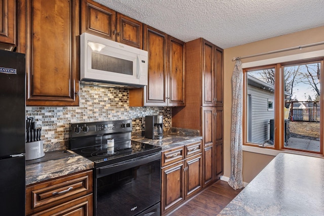 kitchen featuring decorative backsplash, dark countertops, dark wood-type flooring, a textured ceiling, and black appliances