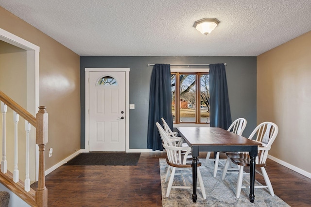 dining space featuring stairway, a textured ceiling, baseboards, and wood finished floors