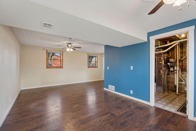 unfurnished room with ceiling fan, a textured ceiling, wood finished floors, and visible vents