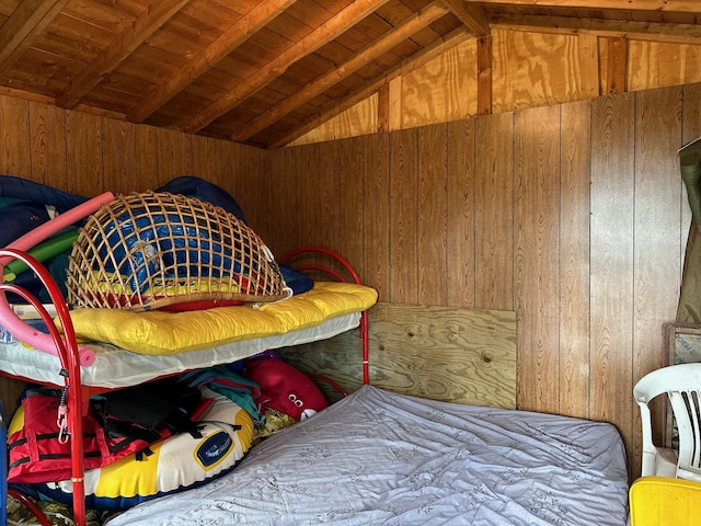 bedroom featuring vaulted ceiling with beams, wooden ceiling, and wooden walls