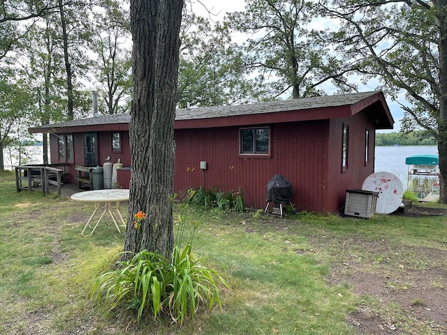 back of house featuring a water view and a yard