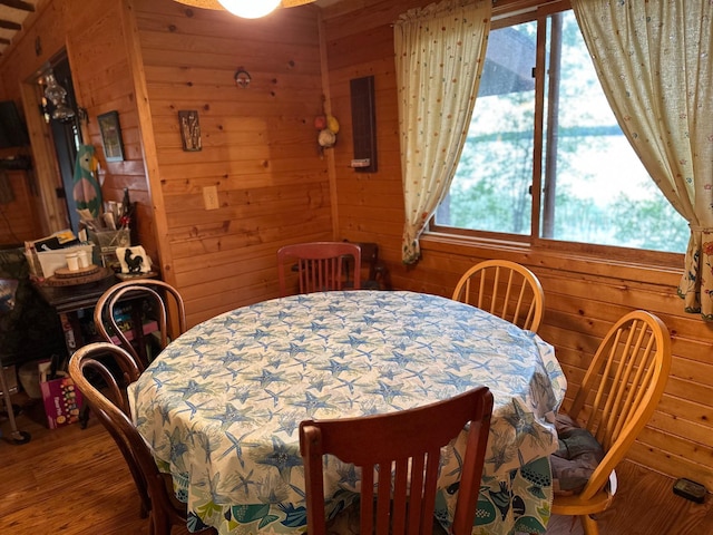 dining area featuring hardwood / wood-style floors and wood walls