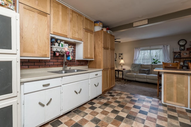 kitchen featuring white cabinetry, sink, and tasteful backsplash