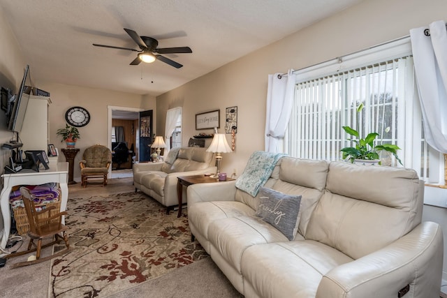 living room with ceiling fan and a textured ceiling