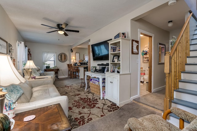 carpeted living room with ceiling fan and a textured ceiling