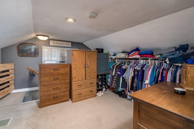 spacious closet featuring lofted ceiling and light colored carpet