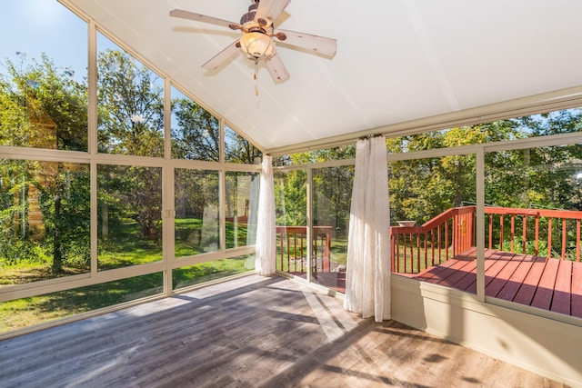 unfurnished sunroom featuring lofted ceiling, plenty of natural light, and ceiling fan